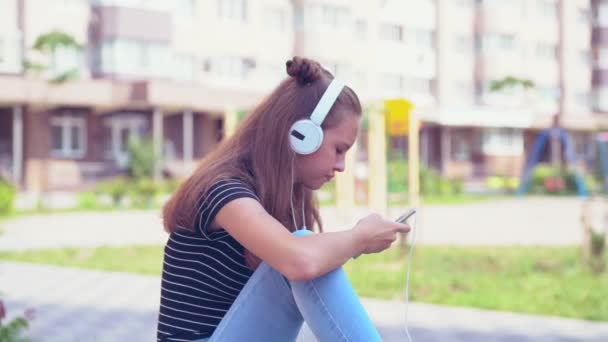 Female teenager staring at phone while seated - Video, Çekim