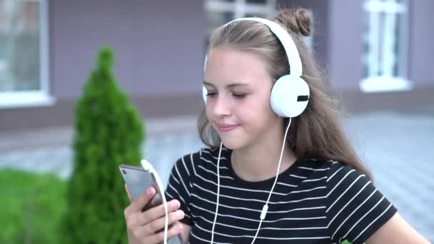 Teenager smiling and waving at phone screen - Felvétel, videó