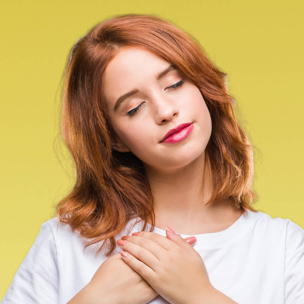 Young beautiful woman over isolated background smiling with hands on chest with closed eyes and grateful gesture on face. Health concept. - Foto, Imagem