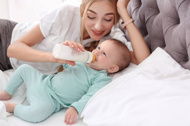 Kobieta, karmienia jej dziecko w sypialni. Dziecko zdrowe jedzenie - Zdjęcie, obraz
