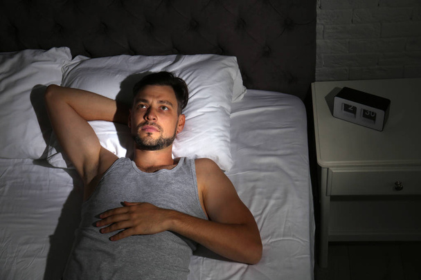 Man suffering from insomnia in bed at home - Foto, Bild