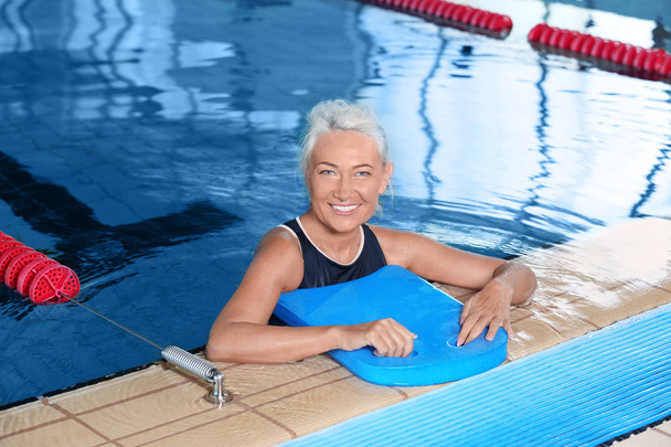 Sportive senior woman in indoor swimming pool - Foto, imagen