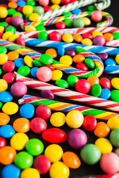 Various colorful candies on black background with selective focus - Photo, Image