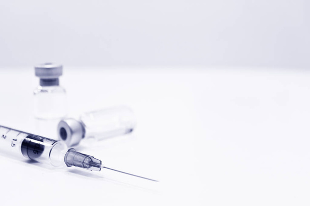 Vial of Drug or Vaccine and 3 ml Plastic Syringe with Needle Isolated on the White Background, blue tone color - Photo, Image