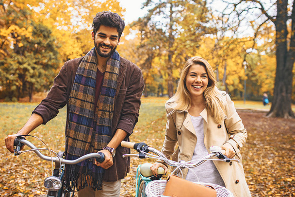 Lächelndes junges Paar genießt Herbst im Park. - Foto, Bild