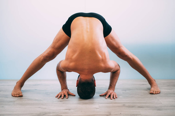 Yoga. Young man doing yoga exercise isolated on a white background. Yogi master workout on white urban studio. Yoga lifestyle healthy concept. - Foto, immagini