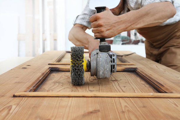 carpinteiro trabalhar a madeira com a lixadeira ferramentas elétricas de moagem para efeitos de madeira rústica
 - Foto, Imagem