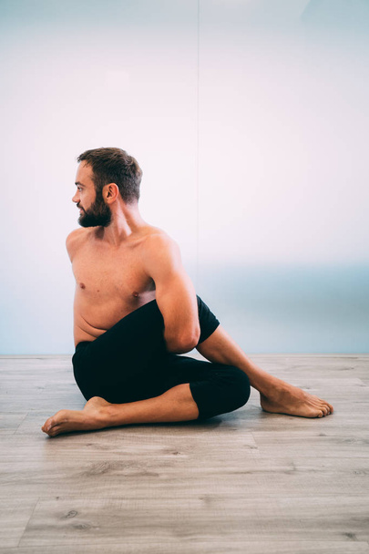 Yoga. Young man doing yoga exercise isolated on a white background. Yogi master workout on white urban studio. Yoga lifestyle healthy concept. - Valokuva, kuva
