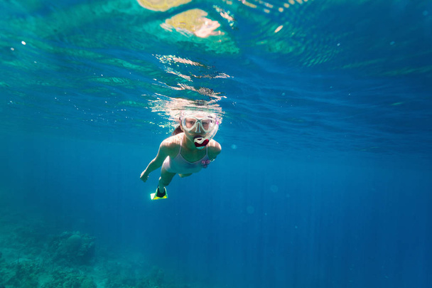 Underwater photo of young girl swimming in tropical ocean - Foto, immagini
