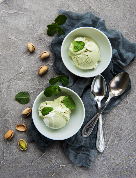 pistachio ice cream and mint with pistachio nuts on a stone background - Fotoğraf, Görsel