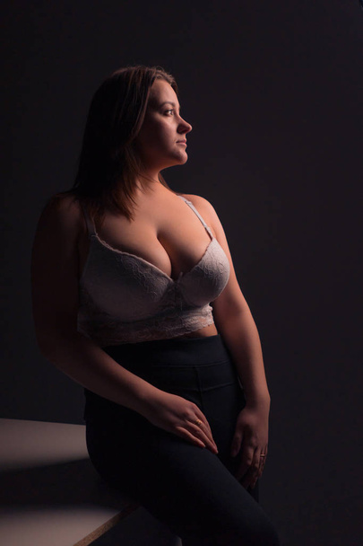 Plus size sexy model in white bra, fat woman with big natural breast on gray studio background, overweight female body, long hair - Photo, Image