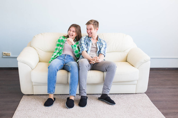 νεαρό ζευγάρι διασκεδάζοντας γέλιο στον καναπέ - Φωτογραφία, εικόνα