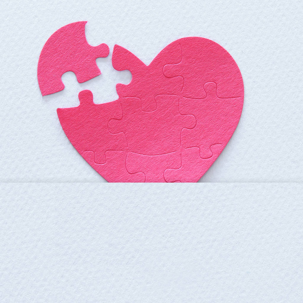 Top view image of paper pink heart puzzle with missing piece over white background. Health care, donate, world heart day and world health day concept - Zdjęcie, obraz
