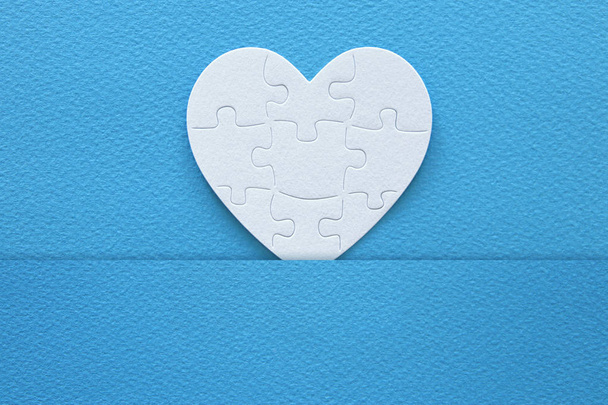 Top view image of paper white heart puzzle over blue background. Health care, donate, world heart day and world health day concept. - Photo, image