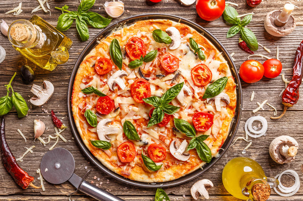 Flat lay with Italian pizza on wooden board and various ingredients - Photo, image
