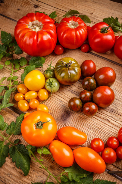 Colorful organic tomatoes on wooden surface - Foto, Bild
