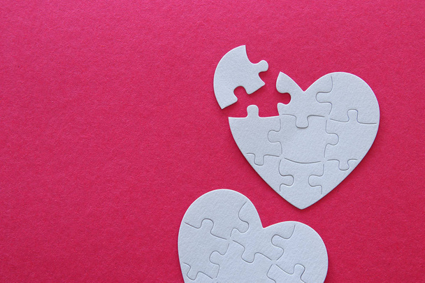 Top view image of paper white heart puzzle with missing piece over pink background. Health care, donate, world heart day and world health day concept - Фото, изображение