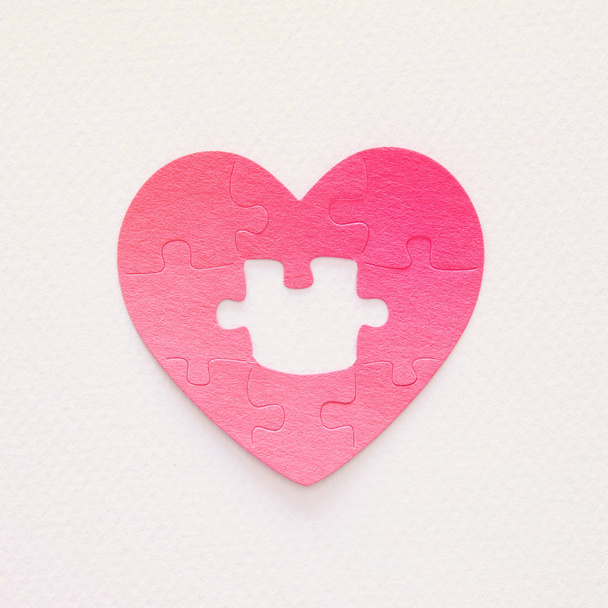 Top view image of paper pink heart puzzle with missing piece over white background. Health care, donate, world heart day and world health day concept - Foto, immagini
