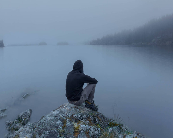 silhueta de um homem na margem do lago
 - Foto, Imagem