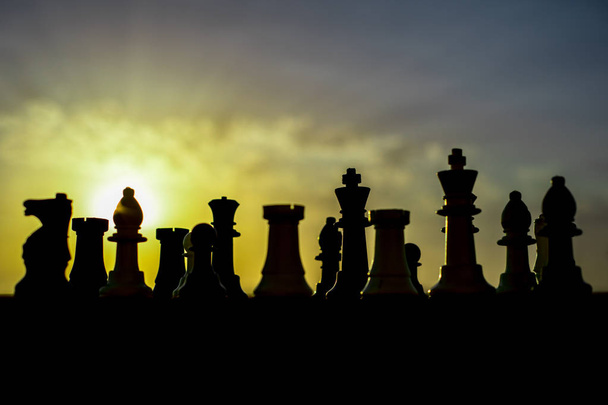 шахматные настольные игры концепция бизнес-идей и конкуренции и стратегических идей. Шахматные фигуры на наружном фоне заката шахматной доски. Селективный фокус
 - Фото, изображение