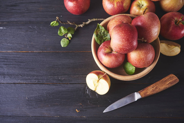 Manzanas rojas maduras jugosas frescas en la mesa de madera con cuchillo
 - Foto, imagen