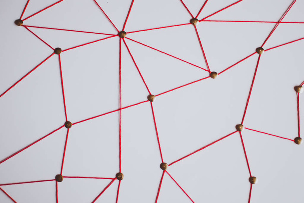 Achtergrond. Abstract concept (idee) van netwerk, sociale media, internet, teamwork, communicatie. Thumbtacks met elkaar verbonden door de rode draad. Geïsoleerd. Entiteiten aangesloten. - Foto, afbeelding
