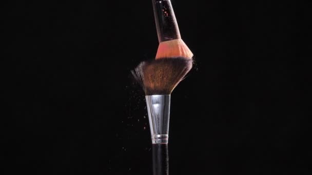 Dwa makijażu pędzel z różowy proszek na czarnym tle - Materiał filmowy, wideo