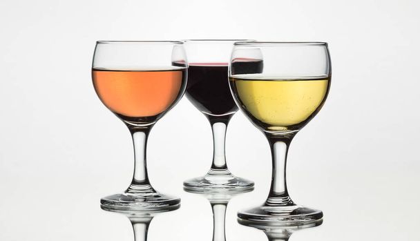 Three glasses of wine isolated on white background with mirror reflection. - Foto, immagini