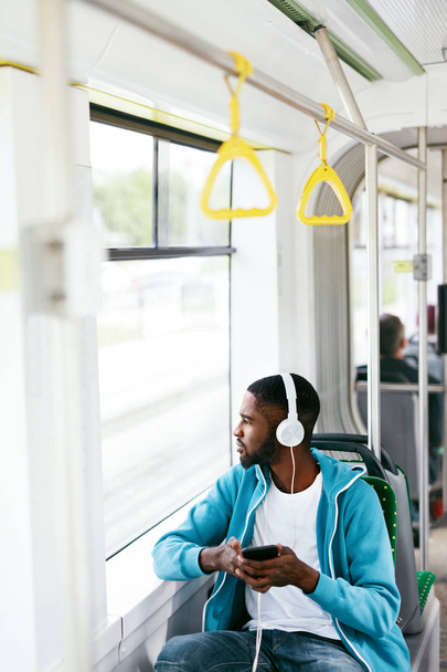 Man rijden In Bus luisteren muziek In hoofdtelefoons - Foto, afbeelding