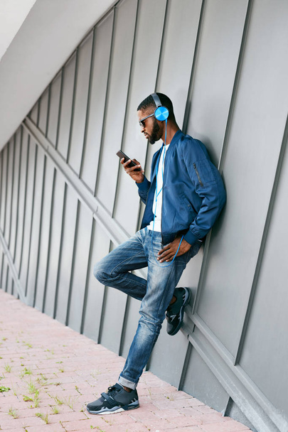 Fashion And Music. Man With Headphones And Phone In City - Фото, изображение
