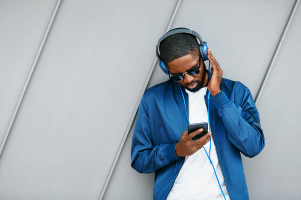 Man Listening Music In Headphones On Phone In Street.  - Foto, afbeelding