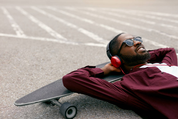 Fashion. Black Man Listening Music In Headphones On Street - Photo, image