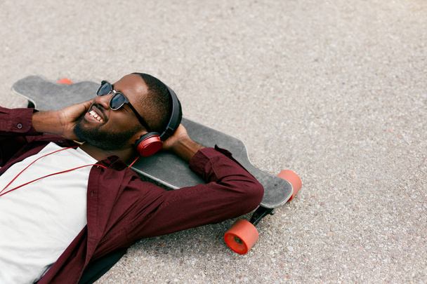 Fashion. Black Man Listening Music In Headphones On Street - Foto, immagini