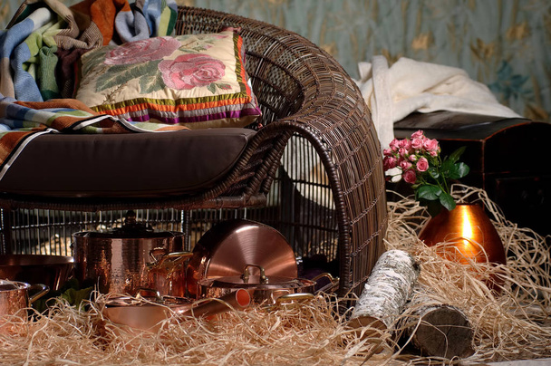 silla de mimbre con una almohada y platos de metal bronce
 - Foto, imagen