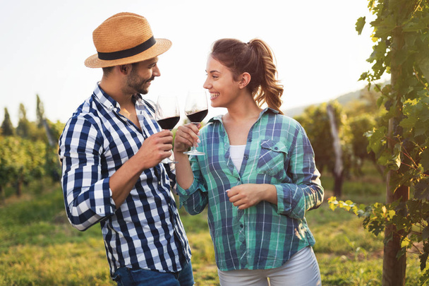 Couple in love working at winemaker vineyard and tasting wines - Фото, зображення