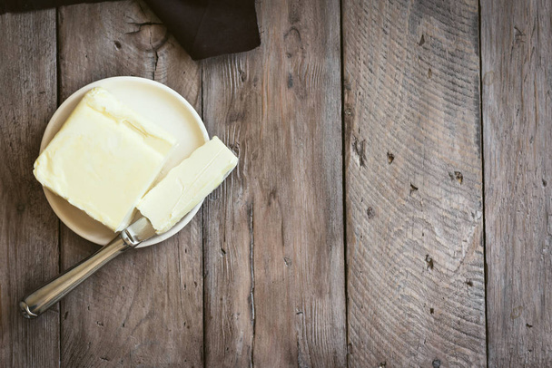 Butter on dark wooden background, copy space. Farm dairy product - butter. - Foto, Bild