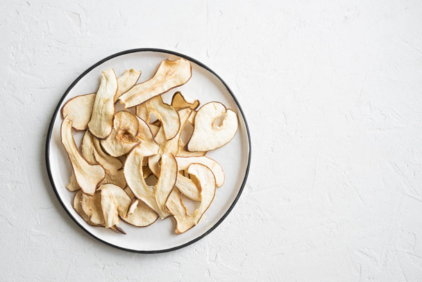 Pear fruit dehydrated chips on white background, copy space, healthy vegan snack. - Zdjęcie, obraz