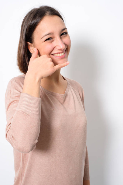 Woman gesturing a phone call with hand isolated on background - Fotografie, Obrázek