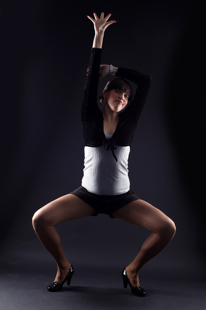 Woman modern dancer against black - Foto, afbeelding