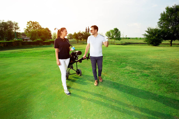 Young couple enjoying time on a golf course - 写真・画像