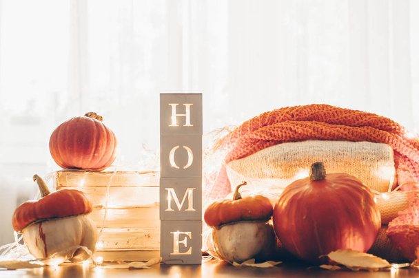 Background with warm sweaters and the inscription HOME. Pile of knitted clothes with leaves, pumpkins. Coziness. Autumn concept - Fotoğraf, Görsel