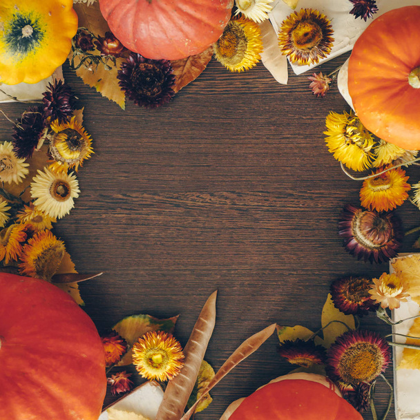Thanksgiving achtergrond met herfst gedroogde bloemen, pompoenen en Herfstbladeren op de oude houten achtergrond. Overvloedige oogst begrip - Foto, afbeelding