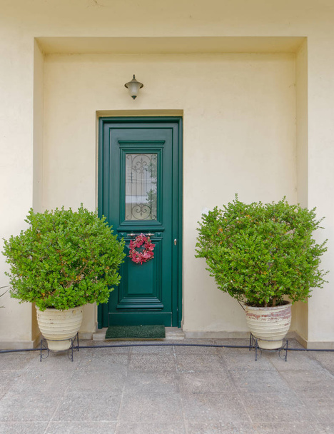 Atenas Grecia, acogedora casa de entrada con puerta verde y plantas
 - Foto, Imagen