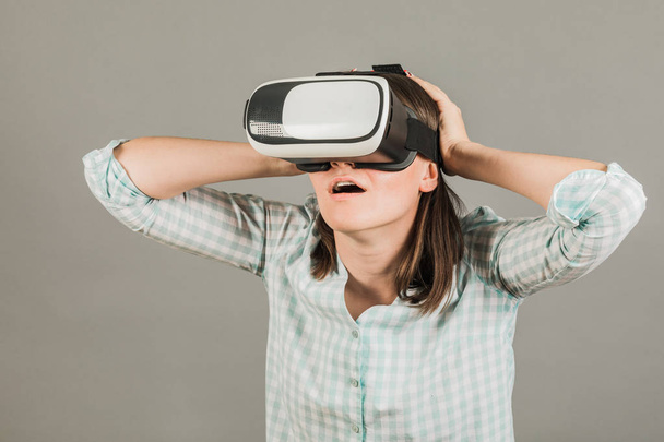 Mujer con gafas de realidad virtual. Concepto de tecnología futura. Sobre un fondo gris
 - Foto, imagen