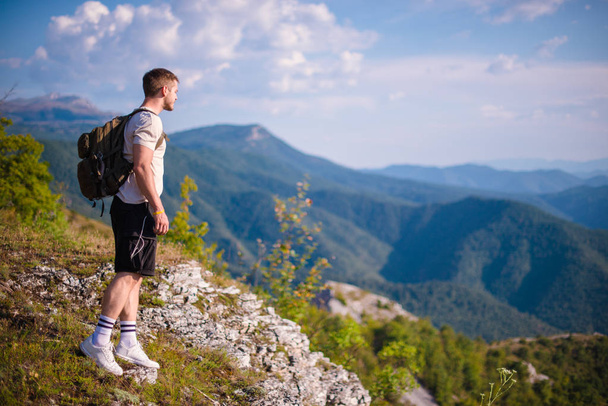Adem de frisse berglucht. Jonge man wandelen in het bos in de zomer. Concept van het wandelen in de bergen in de zomer - Foto, afbeelding