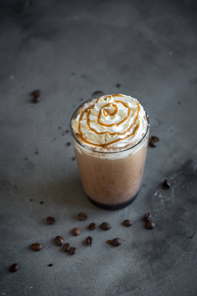 Cold Frappe Coffee (frappuccino) with whipped cream and caramel on dark background, copy space. - 写真・画像