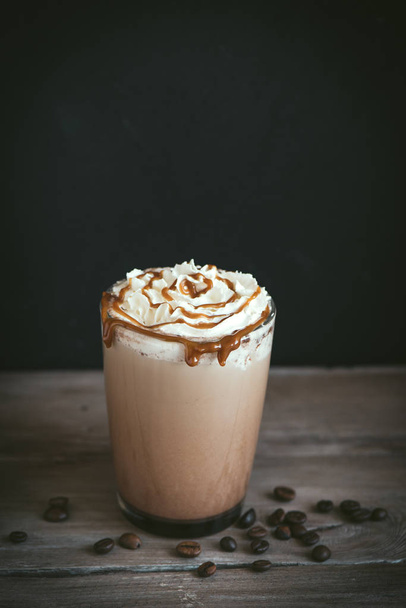 Cold Frappe Coffee (frappuccino) with whipped cream and caramel on dark background, copy space. - Photo, Image