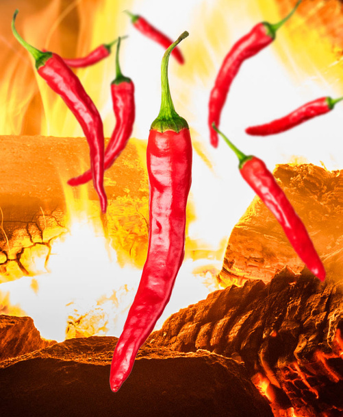 a few pieces of red chili peppers on background with fire - Photo, Image