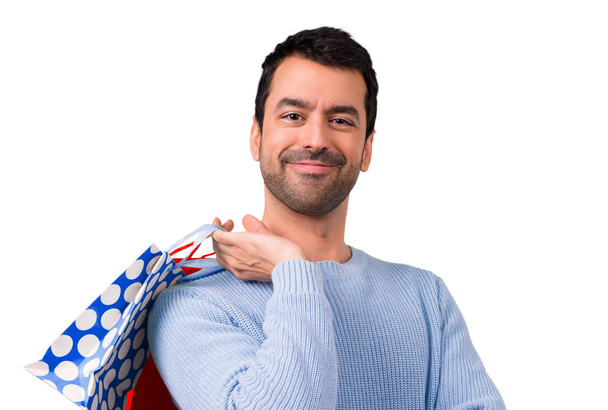 Man with blue sweater holding a lot of shopping bags - Foto, imagen