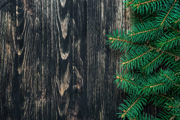 Spruce branches on a dark vintage wooden background. Christmas concept - Zdjęcie, obraz